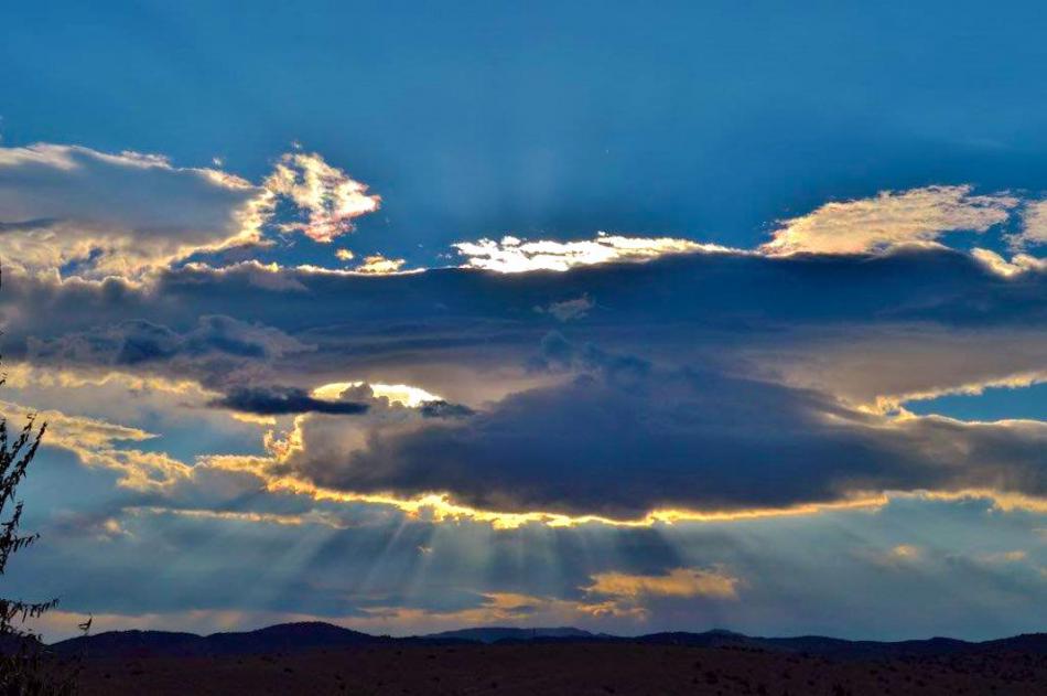 Photo by Brett Fisher. The sun's rays break through clouds east of Carson City.
