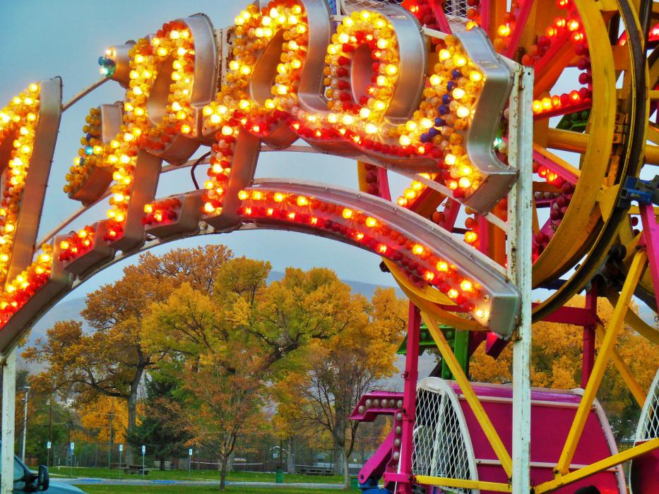 Fall colors framed by the glittering lights of the Zipper ride.