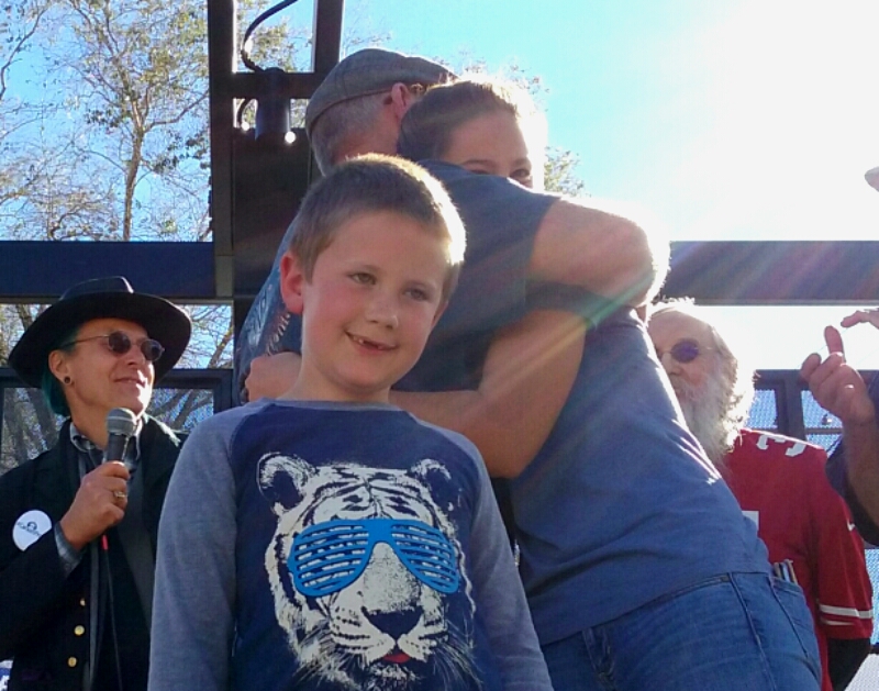 Dean Burkett hugs his granddaughter Taylor as grandson Austin looks on.