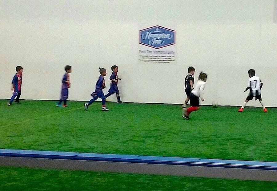 Soccer players chase after the ball during an indoor match at TAC.
