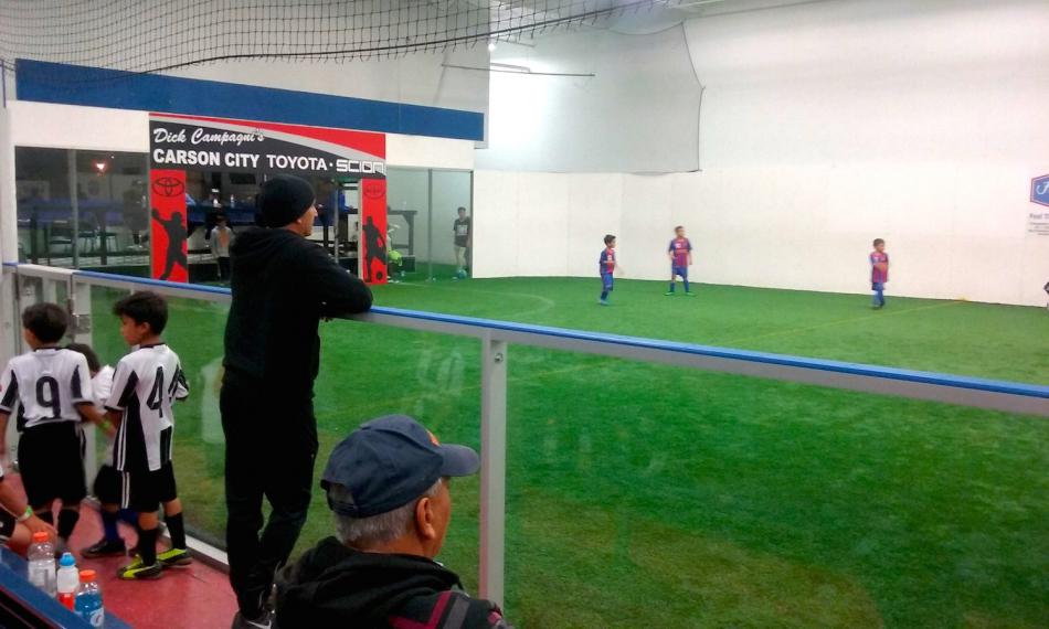 Shams Mobaligh (standing left) coaches an indoor soccer team at TAC.