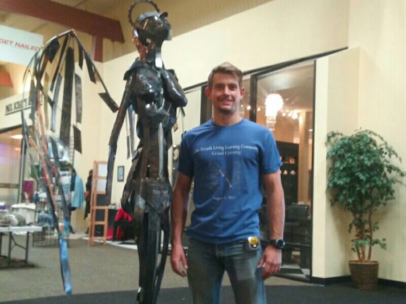 Photo by Brett Fisher. Logan Peterson with his sculpture, "Escape," at the Carson Mall Wednesday.