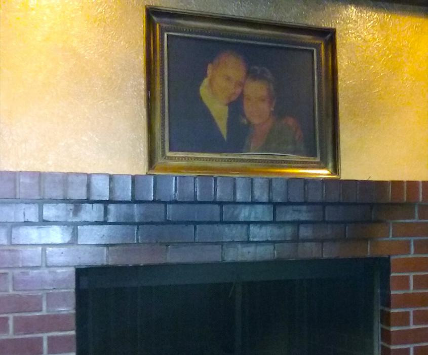 Photo by Brett Fisher. Portrait of Paul and Adele Abowd hangs over the fire place mantle inside Cafe at Adele's.