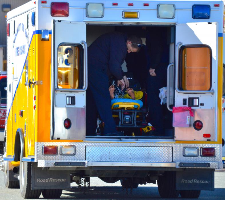 Paramedics work on a simulated cardiac victim in the back of an ambulance.