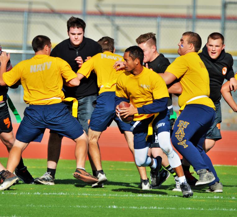 The Carson offensive line blocks for the Navy quarterback.