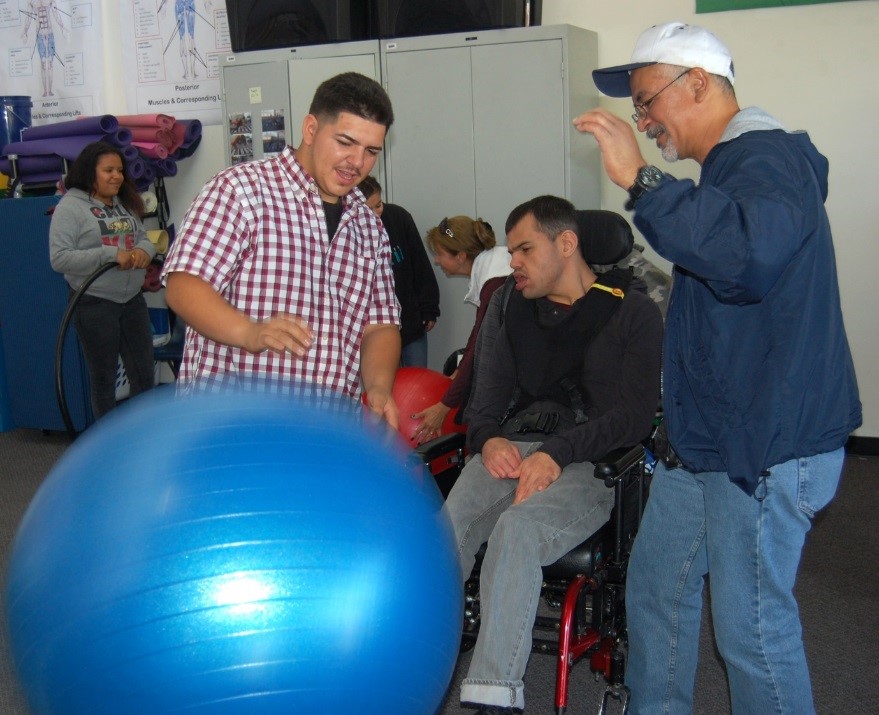 12 grade Pioneer student Victor Chavez demonstrates the fine technique of bowling to visiting EVCH student and staff.