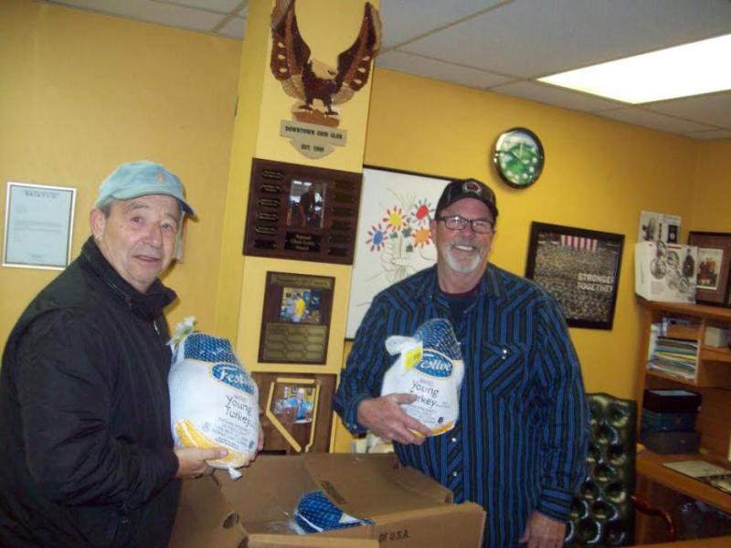 John Syrotynski (left) hands turkeys to John Sorenson of the Dream Center.