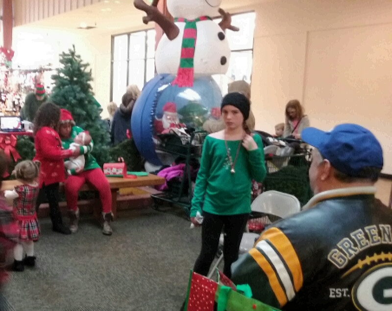 Customers wait to see Santa Claus and have their pictures taken with the Jolly Elf Saturday.