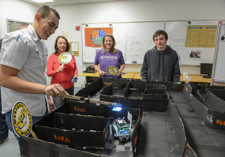 Luis Rowell brings his flashlight-guided robot to the finish of a maze during the Western Nevada College Robot Olympics.