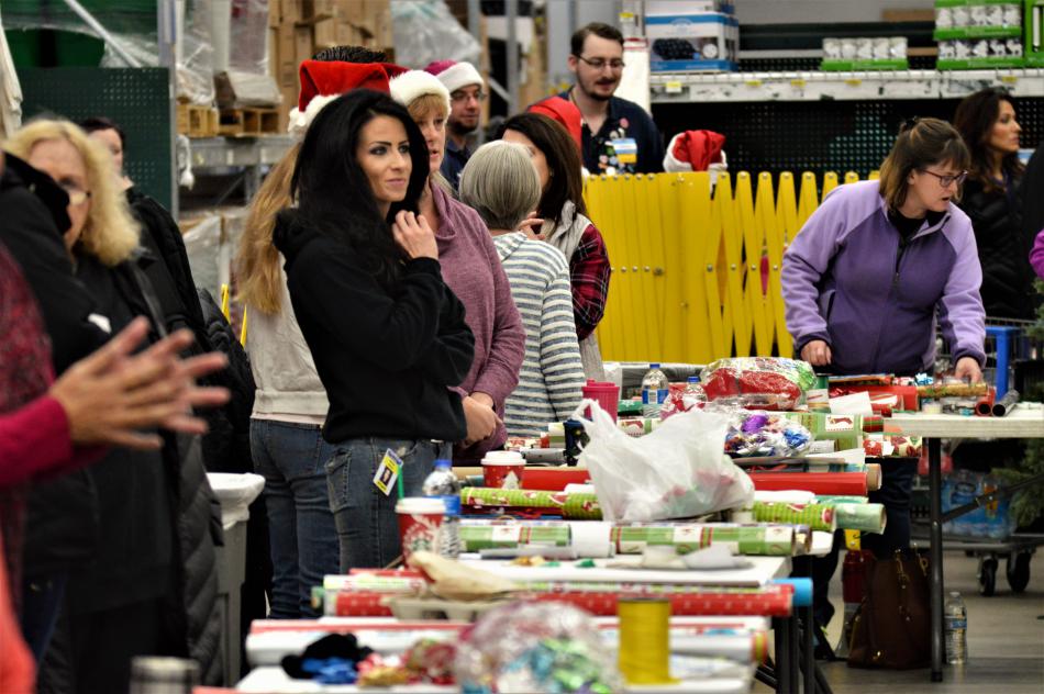 Volunteers wait to help children gift wrap their presents Wednesday morning.