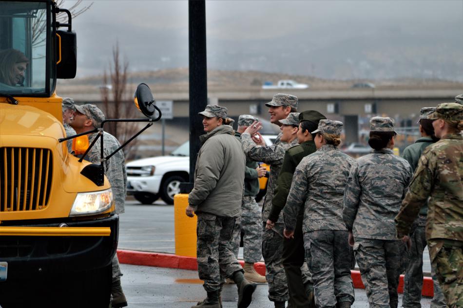 Members of the military greet children arriving on school buses Wednesday.