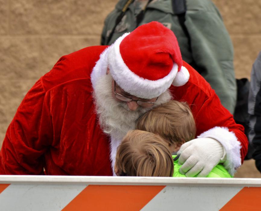 Santa Claus hugs two children upon his arrival at Wal-Mart in North Carson City Wednesday morning.