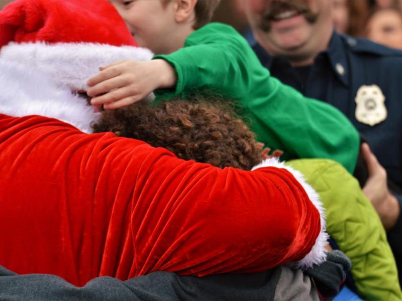 Photos by Brett Fisher. Santa Claus is mobbed by excited children as he greets them in the Wal-Mart parking lot.
