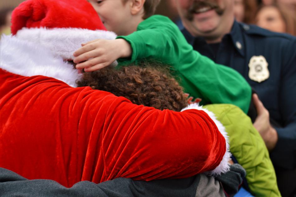 Photos by Brett Fisher. Santa Claus is mobbed by excited children as he greets them in the Wal-Mart parking lot.