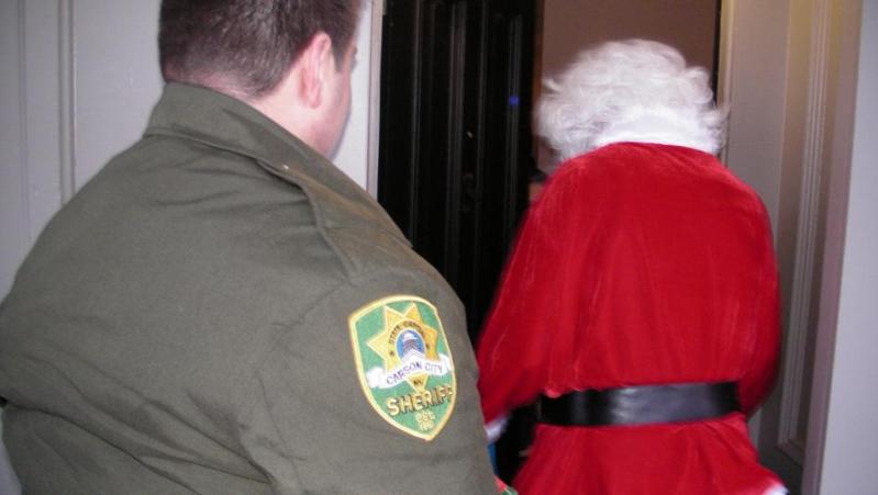 Carson City Sheriff's Reserve Officer Kyle Smith and Santa prepare to enter a home.