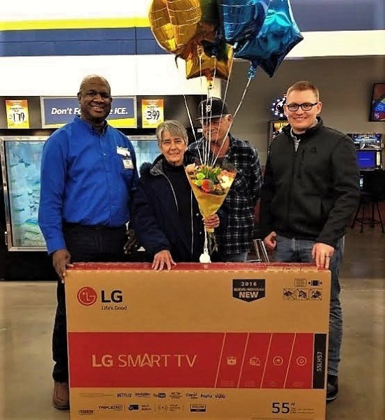 Photo courtesy FoodMaxx. Susan Clemons, center, with her 55-inch LG TV from FoodMaxx.