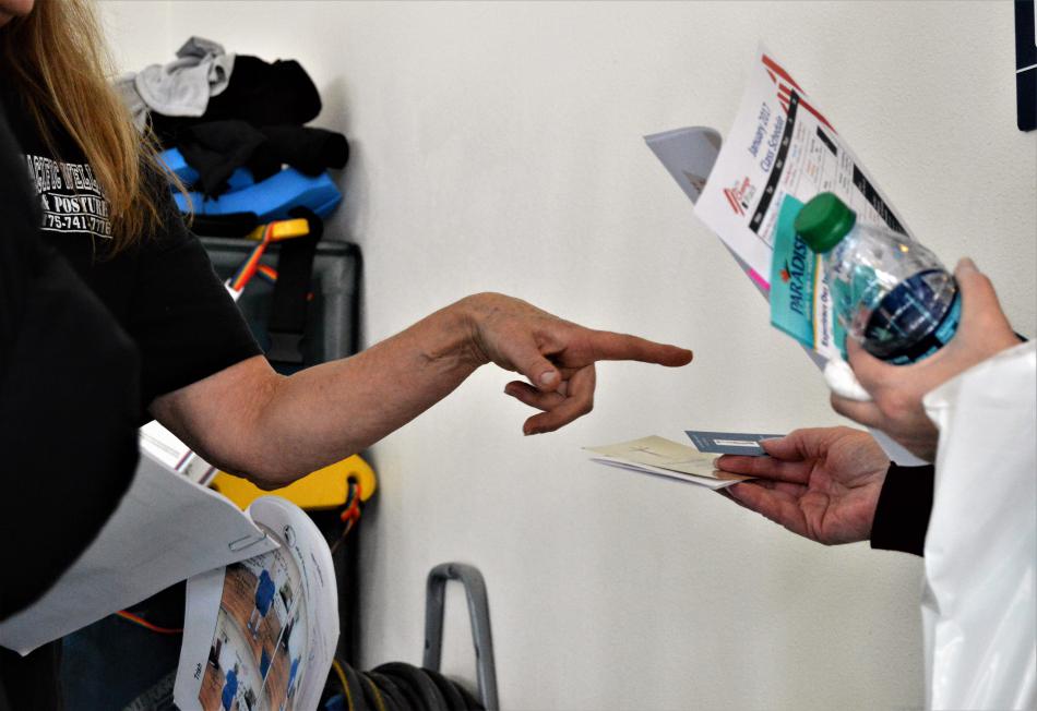A wellness vendor points to literature handed out to a visitor Saturday at Paradise Spa.