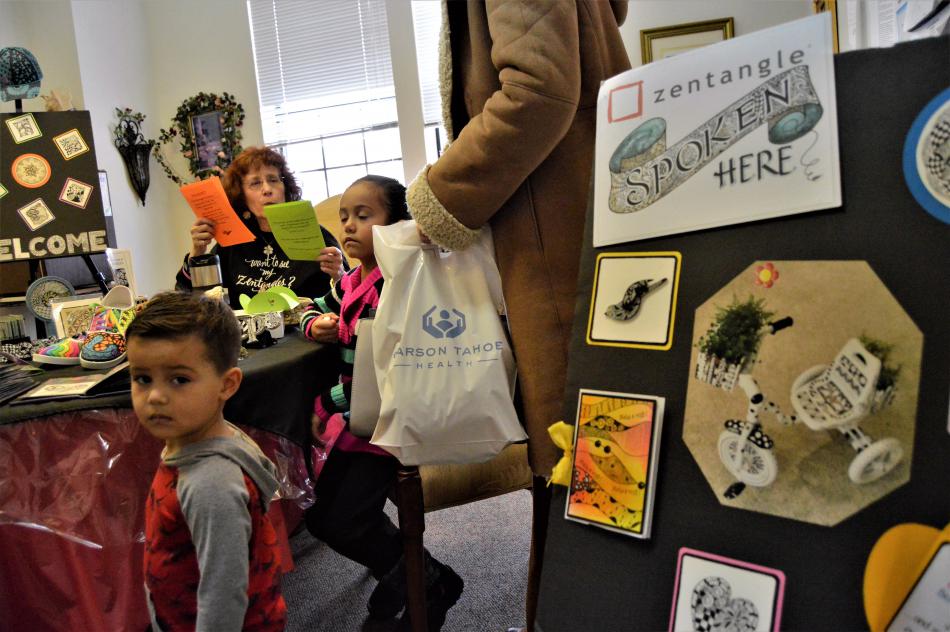 Children visit the Zentangle craft table upstairs at Paradise Spa Saturday.