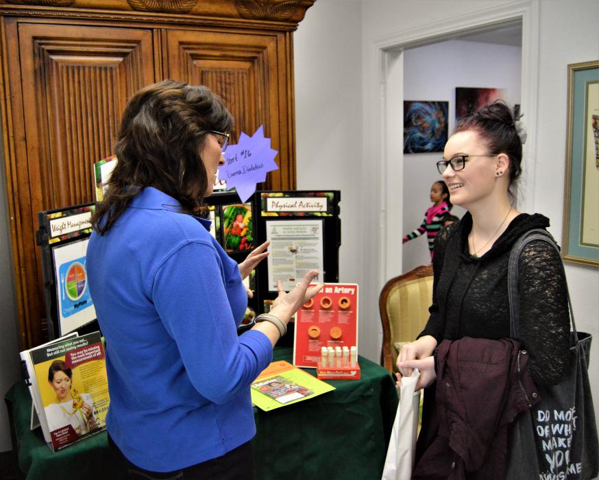 Wellness vendor talking with a visitor Saturday at Paradise Spa.