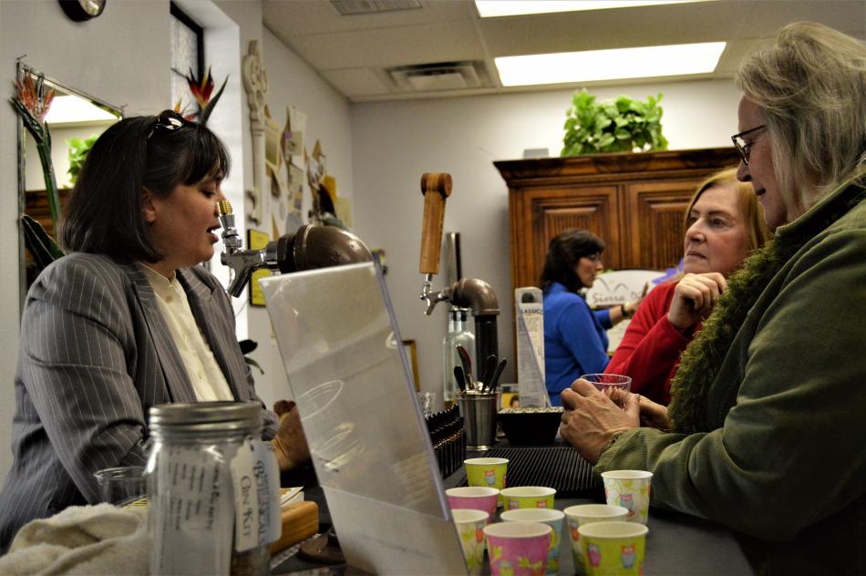 A wellness vendor talks product with visitors inside Paradise Spa Saturday.
