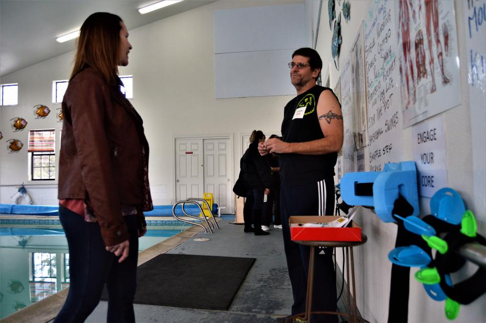 Aqua Zumba Instructor Rick Jordan talks with a wellness visitor Saturday at Paradise Spa.