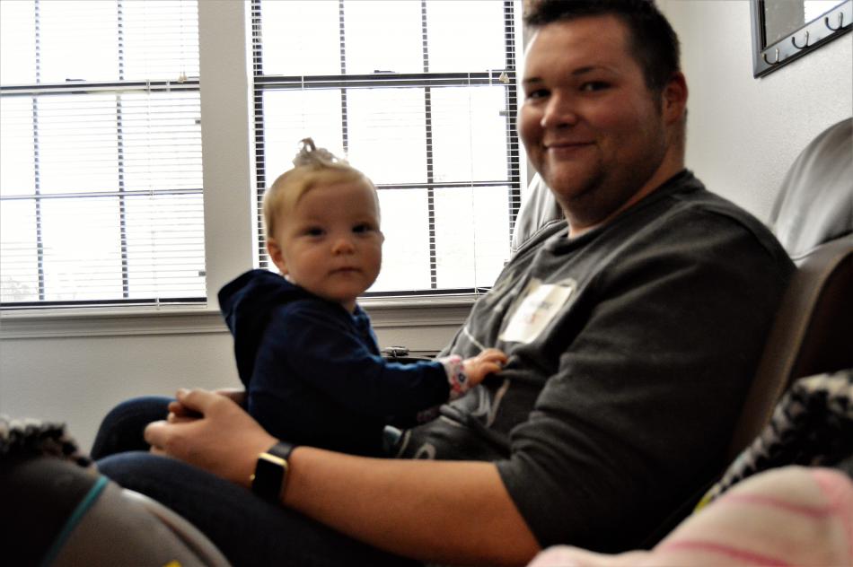 Paradise employee Zack Ames with his godchild Saturday during the wellness fair.