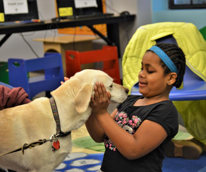A girl is loved up by a therapy dog Saturday at the Carson City Library.