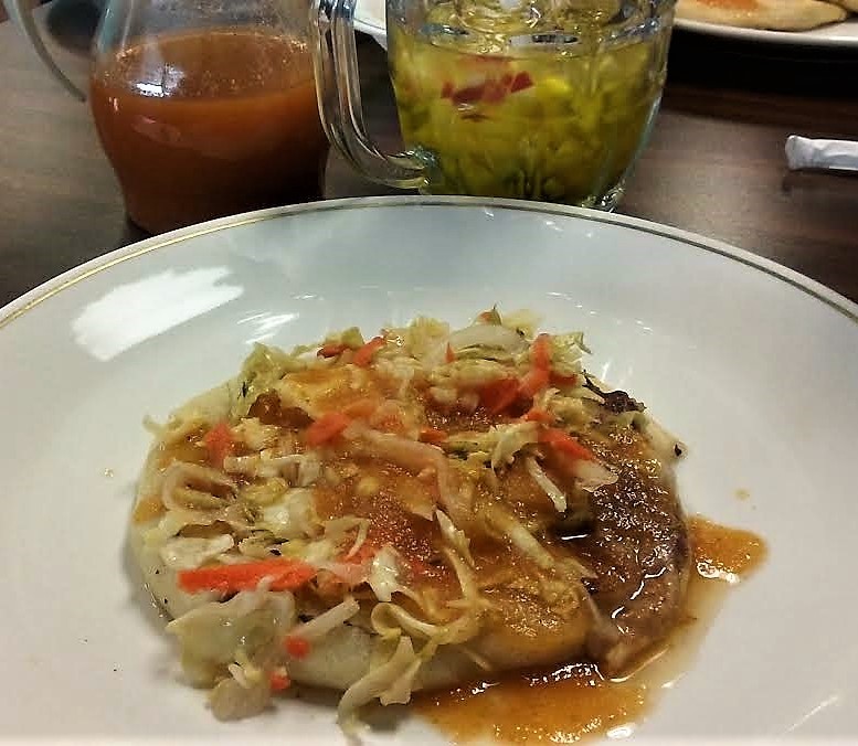 Photo by Brett Fisher. Salvadoran pupusa topped with cabbage salad and salsa.
