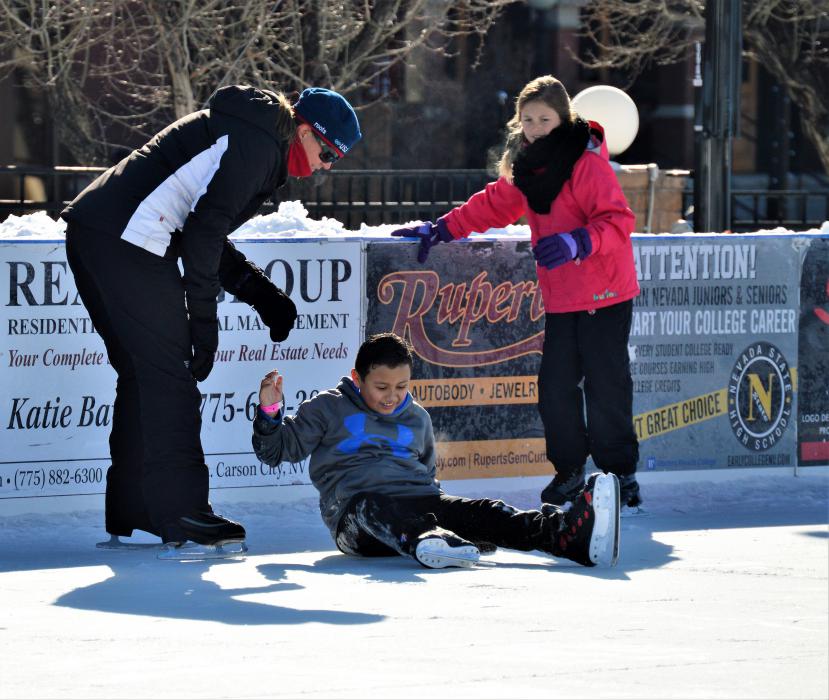 Photos by Brett Fisher. A skater is helped up after losing his balance on the ice Friday morning.