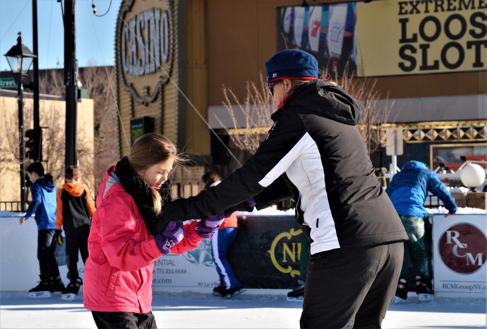 An adult helps a child gain confidence on the ice Friday morning at Arlington Square.