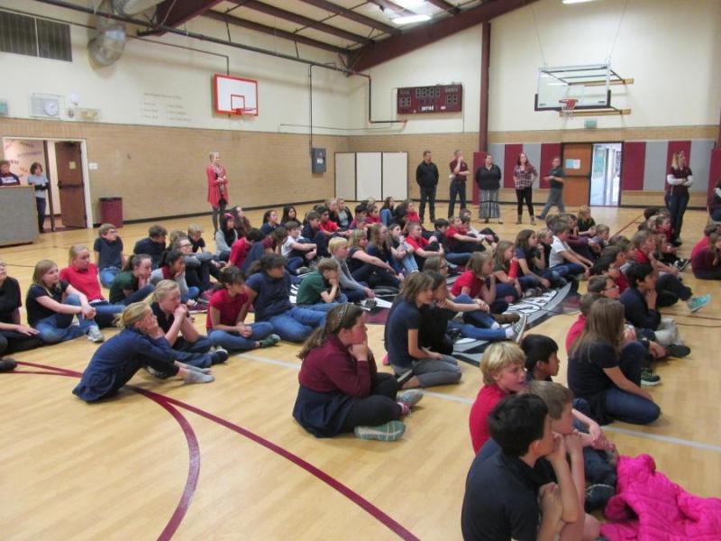 School assembly in which the school presents a check to the Children's Cancer Foundation.