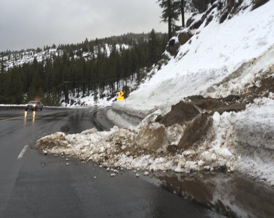 Work crews remove much of the slide debris and boulder.