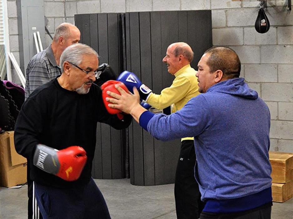 Photos by Lisa Fisher. Cisco Rodriguez (right) helps a member with his punches.