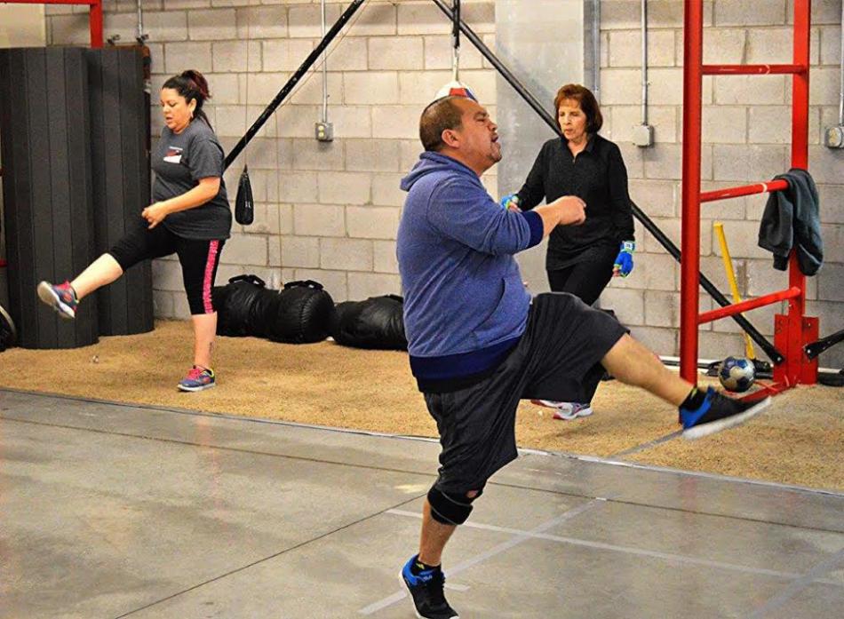 Cisco Rodriguez high steps during the calisthenics warm-up of a Rock Steady work-out.