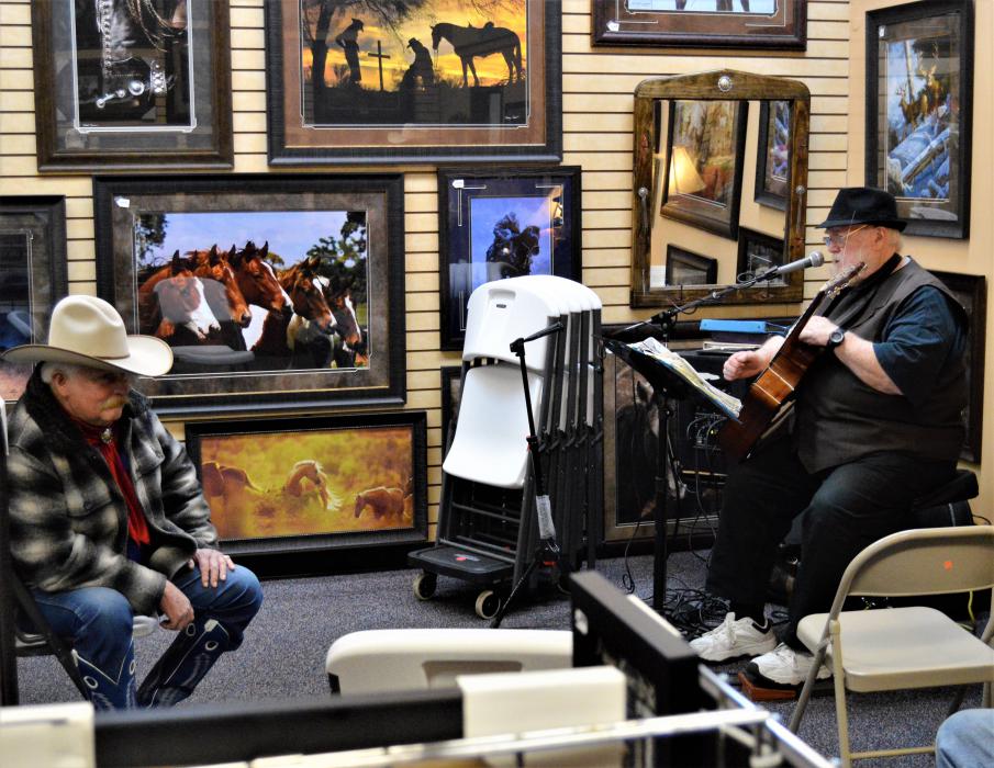 A cowboy listens to live music inside the Wild Horse Gallery Wednesday.