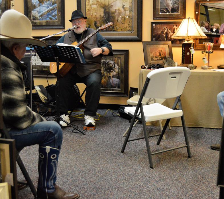A cowboy listens to live music inside the Wild Horse Gallery Wednesday.