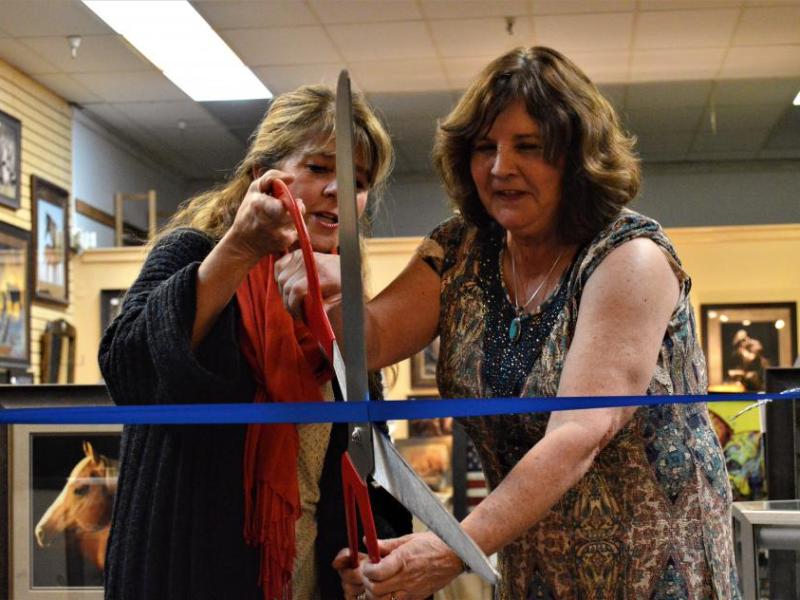 Photos by Brett Fisher. Carson City Supervisor Karen Abowd helps Sheila Hillebrand cut the ribbon Wednesday.