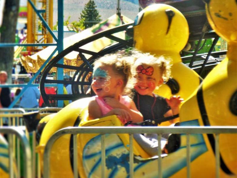 Photo by Brett Fisher. Children on a carnival ride at Mills Park last summer.