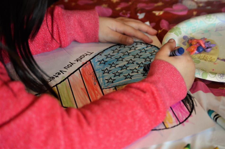 Sadie Edmundson, 4, finishes coloring a Valentine for a military veteran.