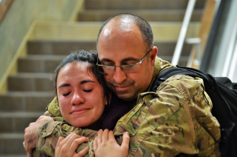 Robert Glass embraces his daughter Cassidy at the bottom of the escalator.