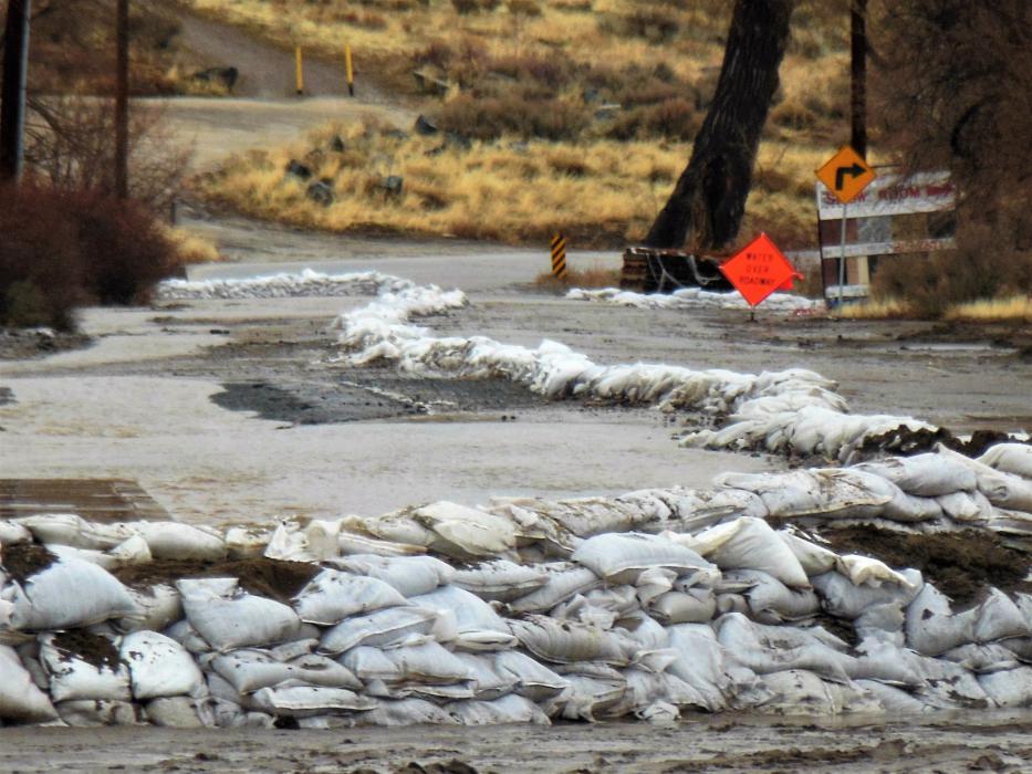 Photo by Brett Fisher. Sandbags divert flood waters from Rhodes St. along South Curry.
