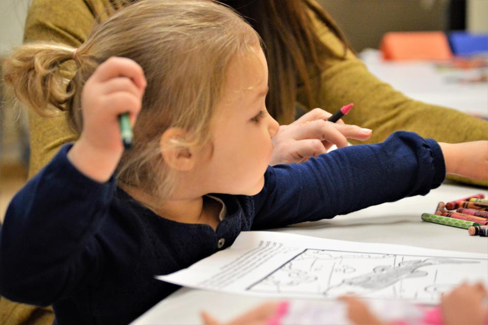 A little girl and her mother at a coloring station inside the Nevada State Museum.