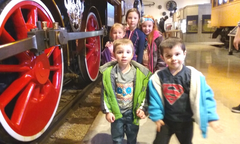 Photos by Brett Fisher. Children next to an historic engine artifact inside the NSRM.