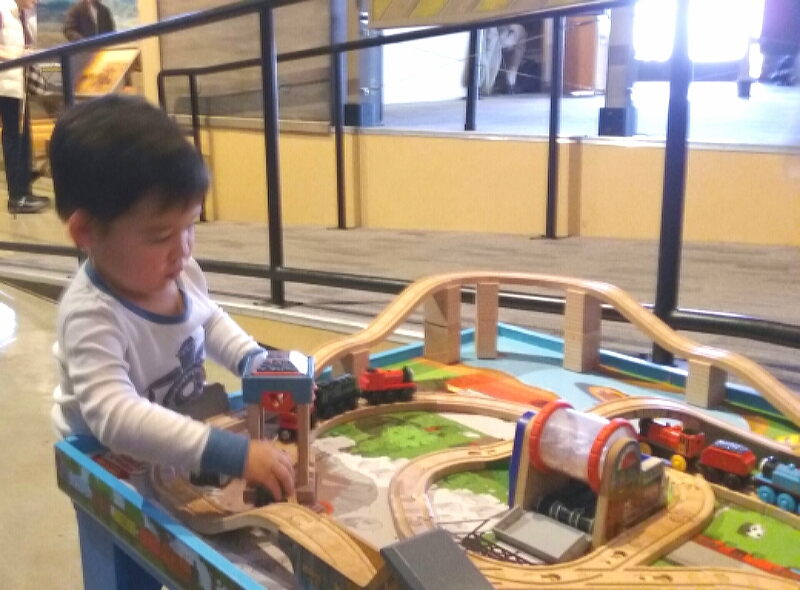 A small child plays with toy trains inside the NSRM Saturday.