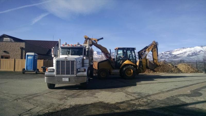 Green Lizard Landscape loads truck with excavated material.