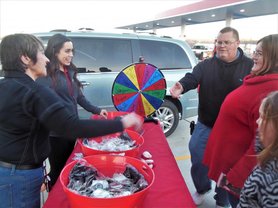 Photos by Brett Fisher. Customers spin a wheel for giveaways at the new Maverik.