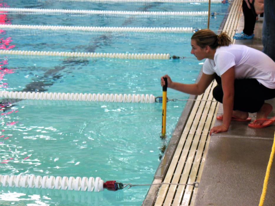 A signaler keeps her swimmer informed of the number of laps she has swum.
