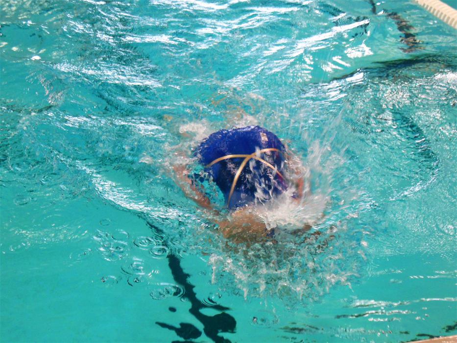 A swimmer turns over at the wall to begin another lap.
