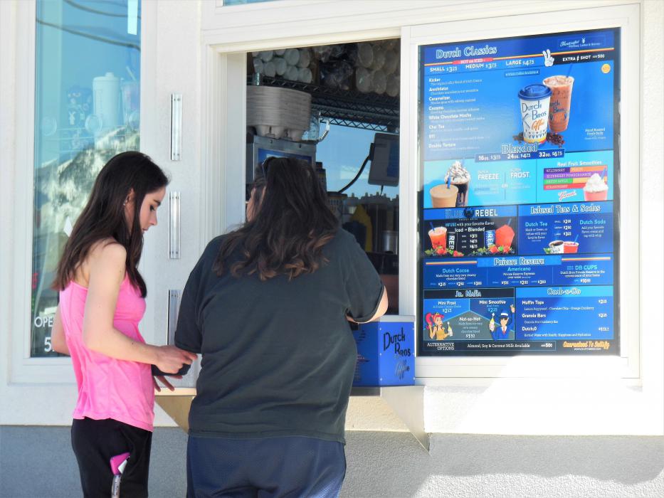 Photos by Brett Fisher. Customers order from the walk-up window Monday at the new Dutch Bros. on E. William St.