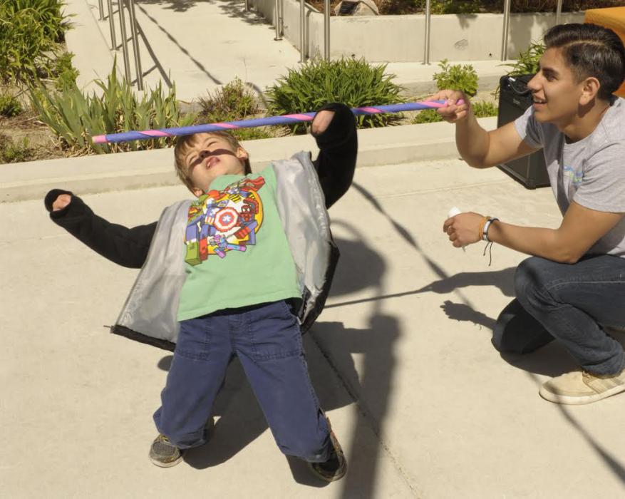 Gage Kingsland, 6, plays limbo as Adrian Barrera, 18, holds the bar during the 2016 Easter Egg Fiesta at WNC.
